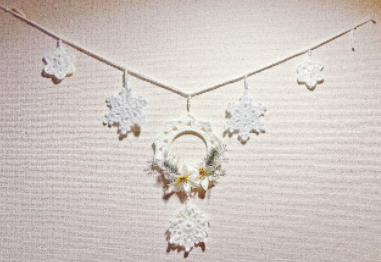 雪の結晶とフラワーアレンジメントが組み合わさったタペストリーの写真。壁に飾られている様子。
