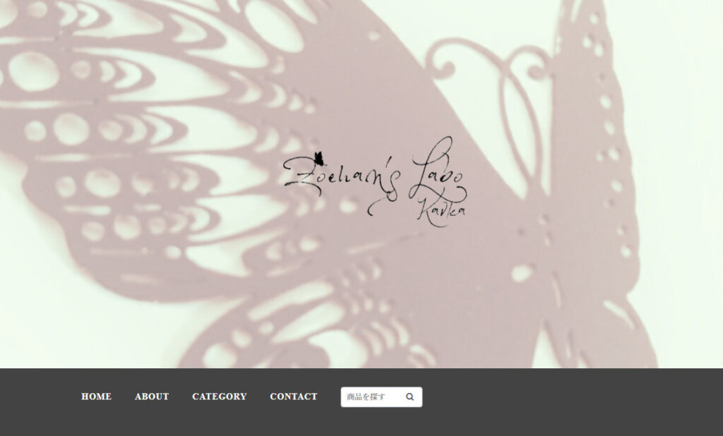小林さんのネットショップのトップ画像。透かしで表現されたアゲハ蝶の切り絵を背景に、手書き風の書体でショップ名が中央に置かれている。