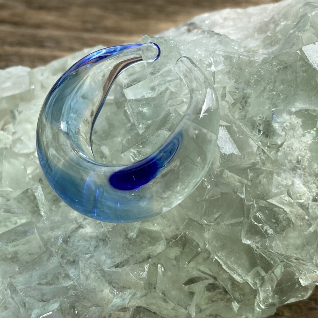 三日月のような形をしたガラスのイアリング。透明な中にブルーグラデーションが幻想的で、1滴の雫をイメージしている
