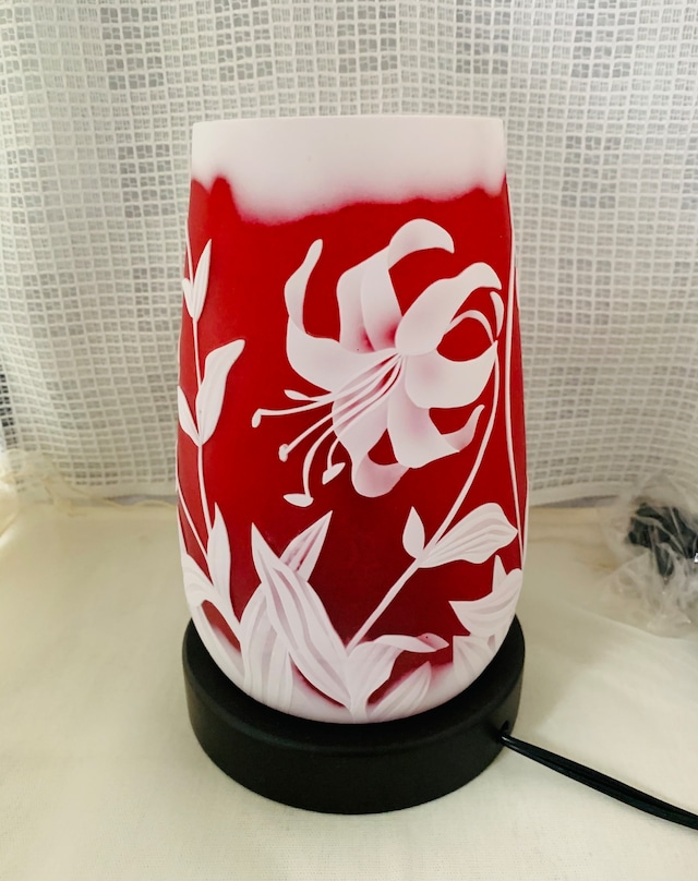 「ユリのランプ」という商品の写真。ユリの花が見えるように置かれている様子。