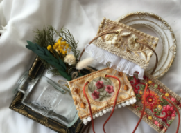 瀬戸みさ子さんのショップfleurienのトップ画像、白の布の上にインド刺繍リボンのヘアアクセサリーやお皿、フレーム、お花が飾られている