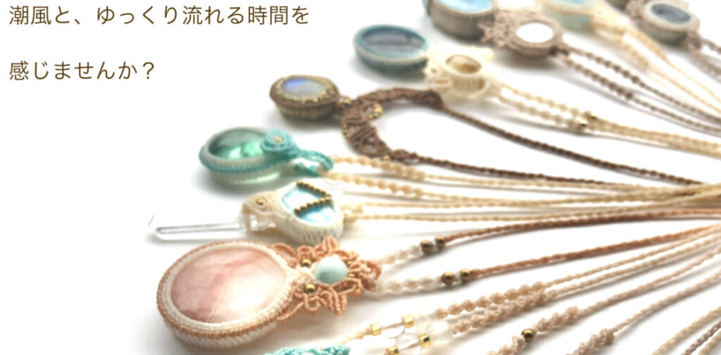 辻歩さんのショップAyumi Handmade Macrameのトップ画像、白背景にベージュ、緑、ブルーの石のマクラメ編みネックレスが並んでいる