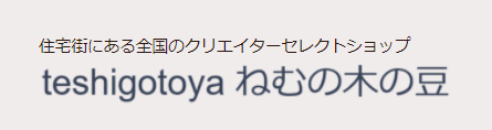 田中ひとみさんのショップteshigotoya ねむの木の豆のトップ画像、グレーの背景にショップ名が書かれている