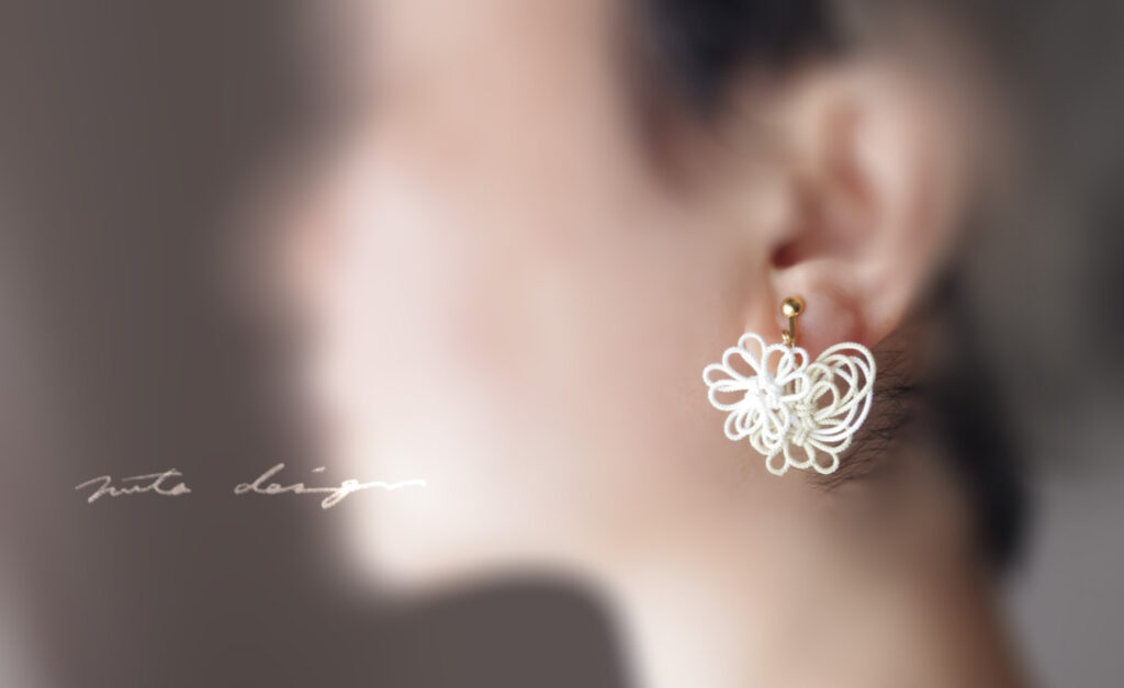佐伯ゆう子さんのショップnuta designのトップ画像、女性が横を向き、その耳に白い飾り結びのイヤリングがついている。左側にショップ名が書かれている。
