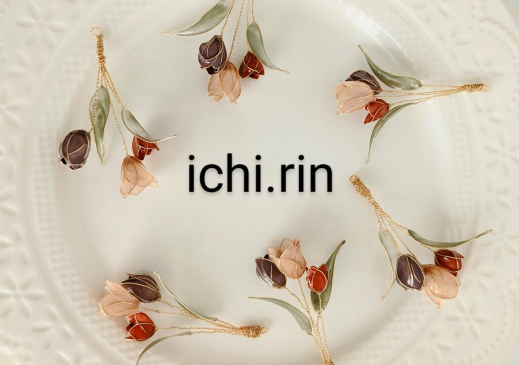 市川真梨さんのショップichi.rinのトップ画像、白いお皿の上にワイヤーで作ったピンク、赤、紫のチューリップが並んでおり、その真ん中にショップ名が書かれている