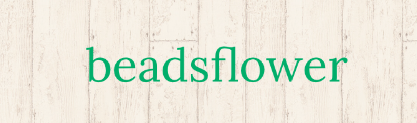 原桂乃さんのショップbeadsflowerのトップ画像、木目柄にショップ名が書かれている