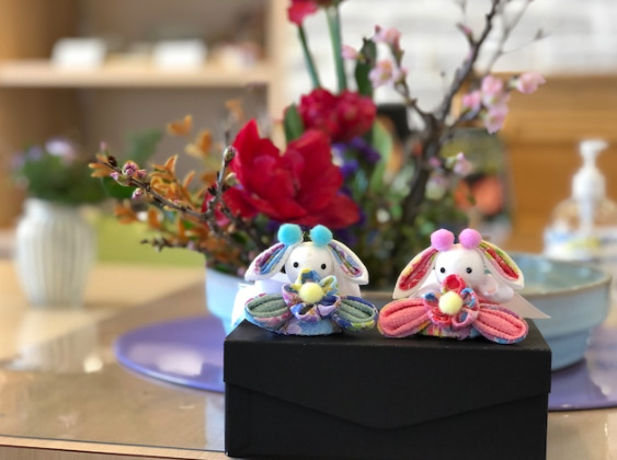 お花の飾られたテーブルの手前に、水色とピンクのウサギデザインお雛様が置かれている
