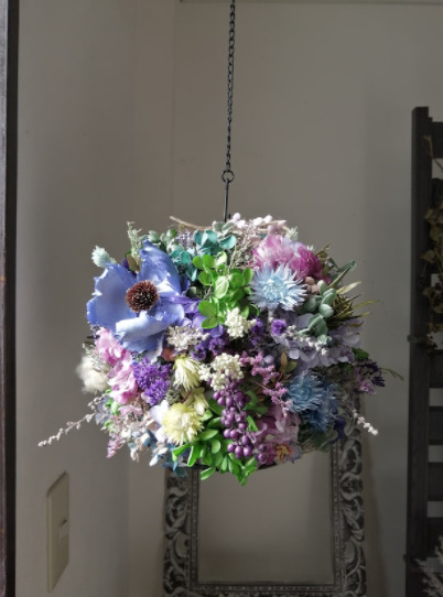 お部屋にブルーやパープル、緑のお花、葉っぱを使って作ったランプシェードが飾られている