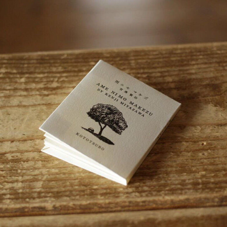 天地76×左右63×厚さ5mm のミニブックです。表紙は活版印刷で「雨ニモマケズ」宮沢賢治と書かれていて、木のイラストが描かれています。