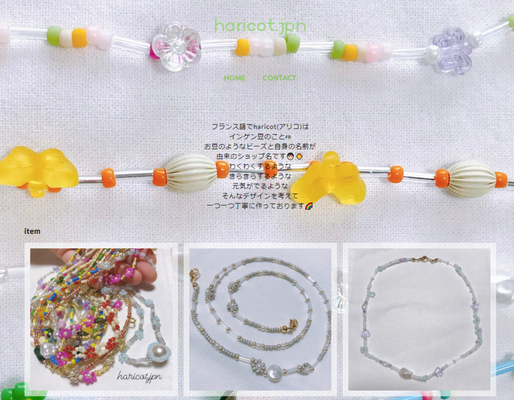 井上さんのお店のトップ画像。白やピンク、黄緑やオレンジのカラフルなビーズに小さなお花が添えられたネックレスや、オレンジの蝶のビーズネックレスのアップ写真が背景に使われている。
