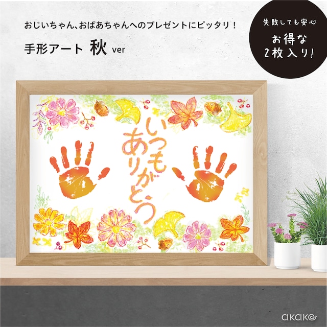 手形アートの写真。秋の植物が描かれた台紙の中央に「いつもありがとう」という文字と、子どもの手形が押されている。