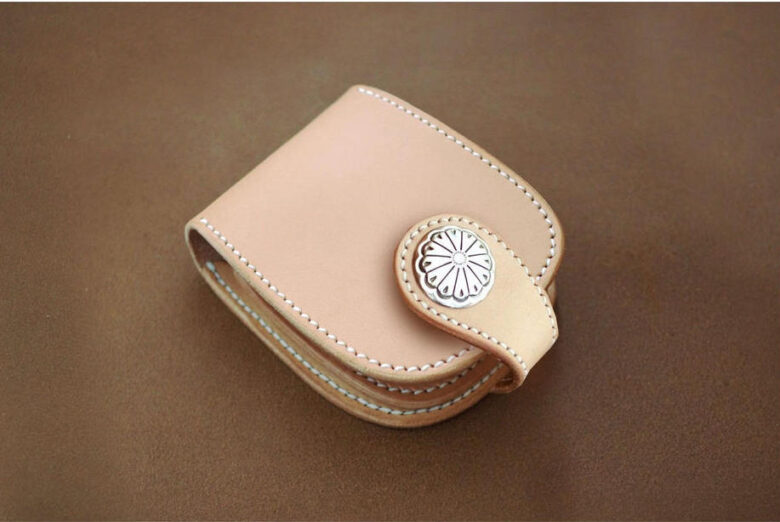 財布は約14cm×約9cm×約3cm とコンパクトですが、革自体の厚みがしっかりあり、丈夫。フラップタイプで留め具がついています。