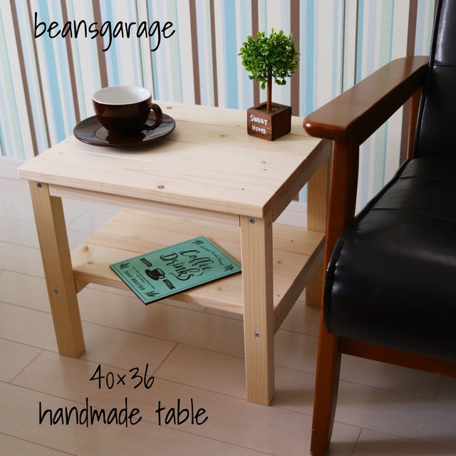 ローテーブルの写真。椅子の横に置かれ、一段目にはコーヒーカップと植物が、二段目には雑誌が置かれている様子。