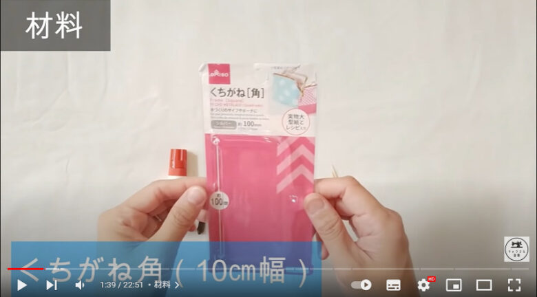 使用する100円商品のパッケージを両手にとって紹介しています。