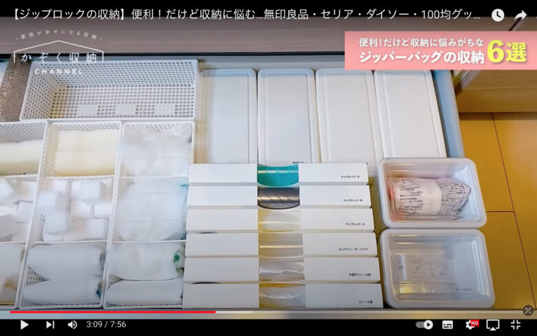 キッチンの引き出しが大きく引き出されている。中には白いケースとカゴが並んでいる。ケースの中にはジップロックが種類ごとに分けて入れられ、カゴには台拭きやメラニンスポンジなどが種類ごとに分けて収納されている。