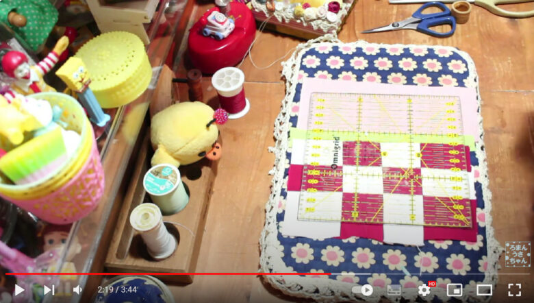作業台の上に縫い合わせた布が置かれている様子。布の上には、15cm×15cmの正方形の定規が置かれていている。